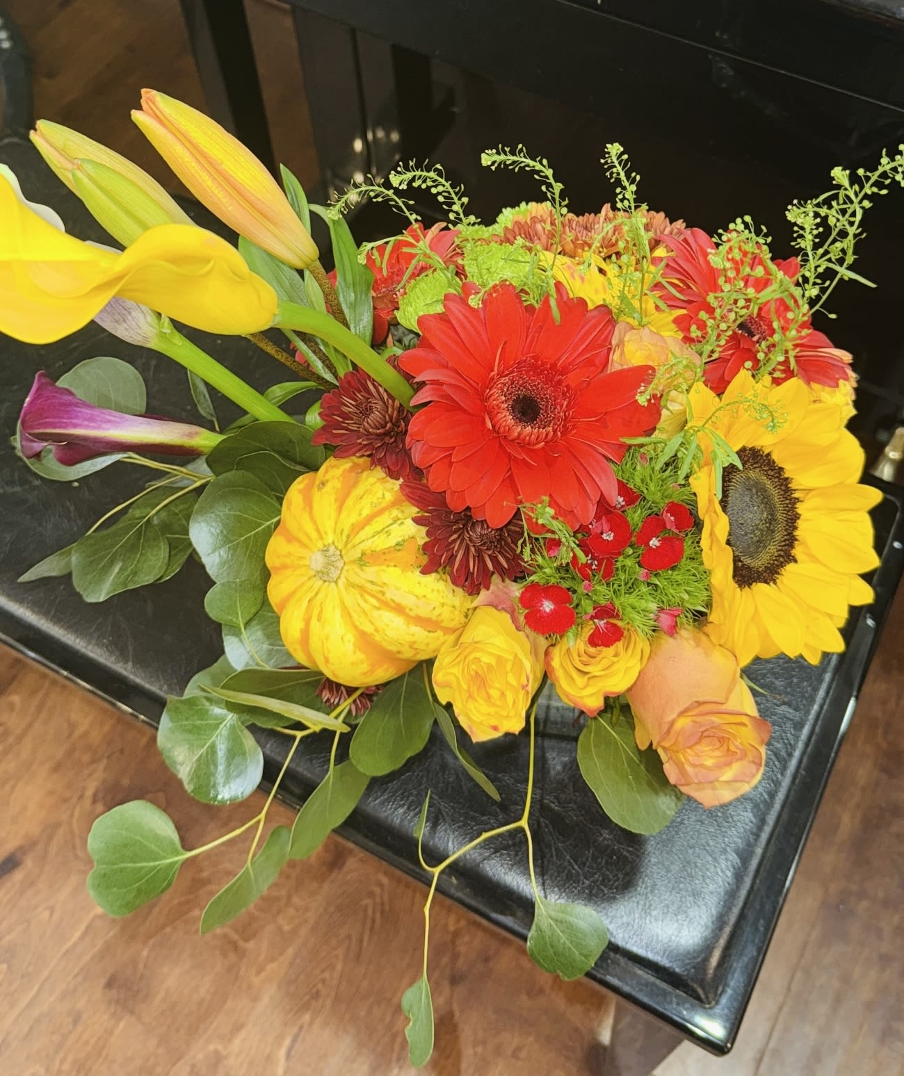Bright mixed bouquet with sunflowers, gerbera daisies, roses, and calla lilies