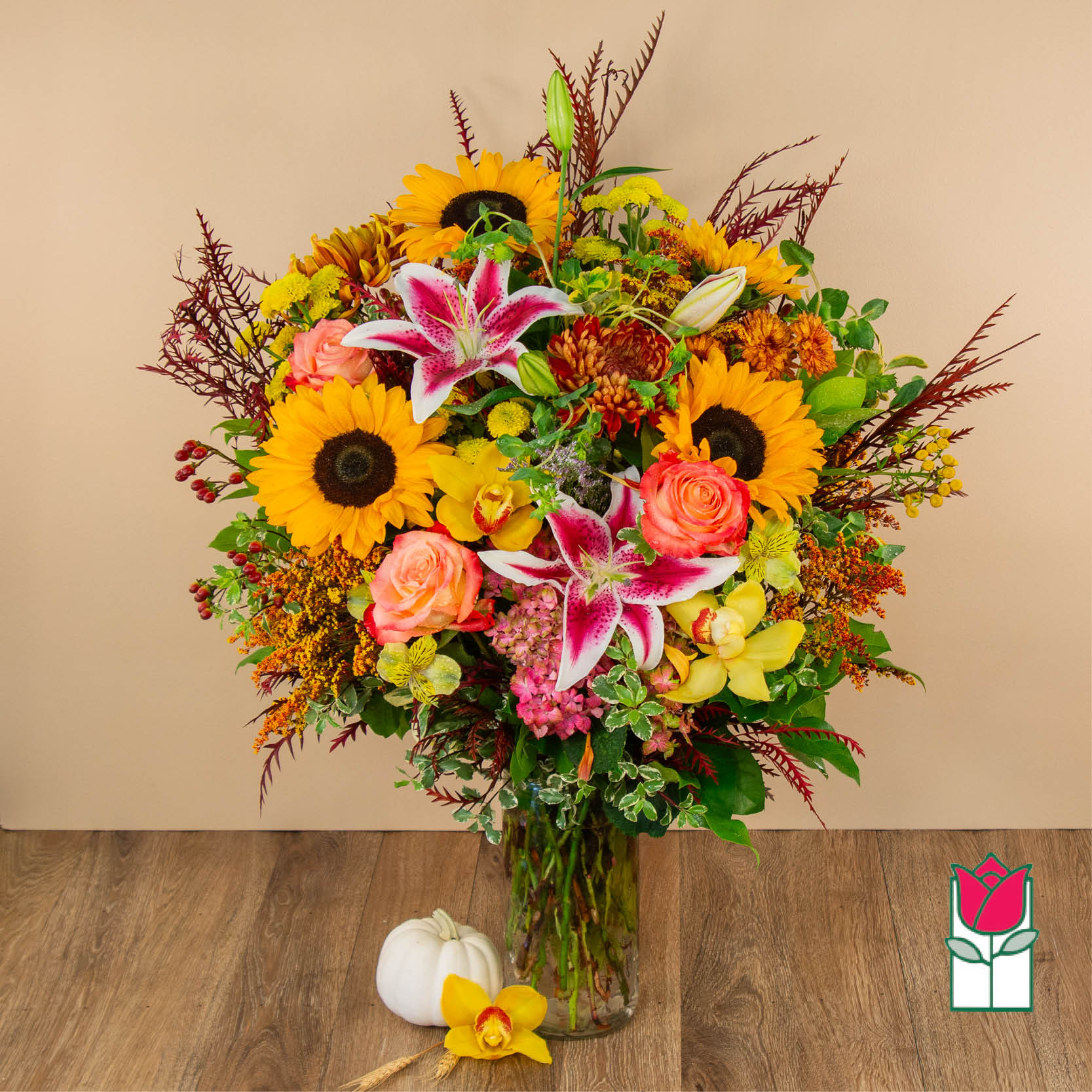 Mixed bouquet in a glass vase with sunflowers, lilies, and roses