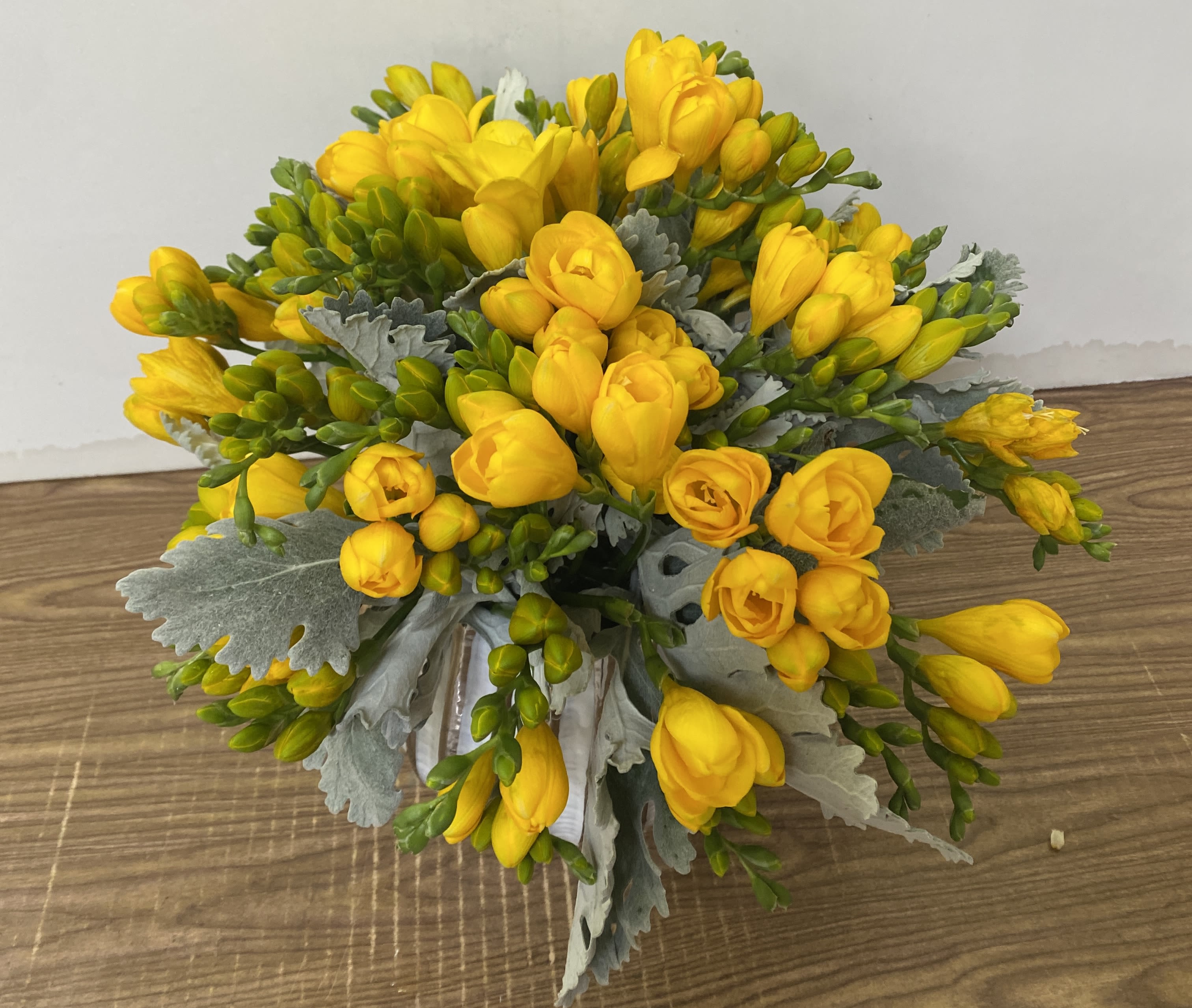 Bouquet of yellow freesia with silvery foliage