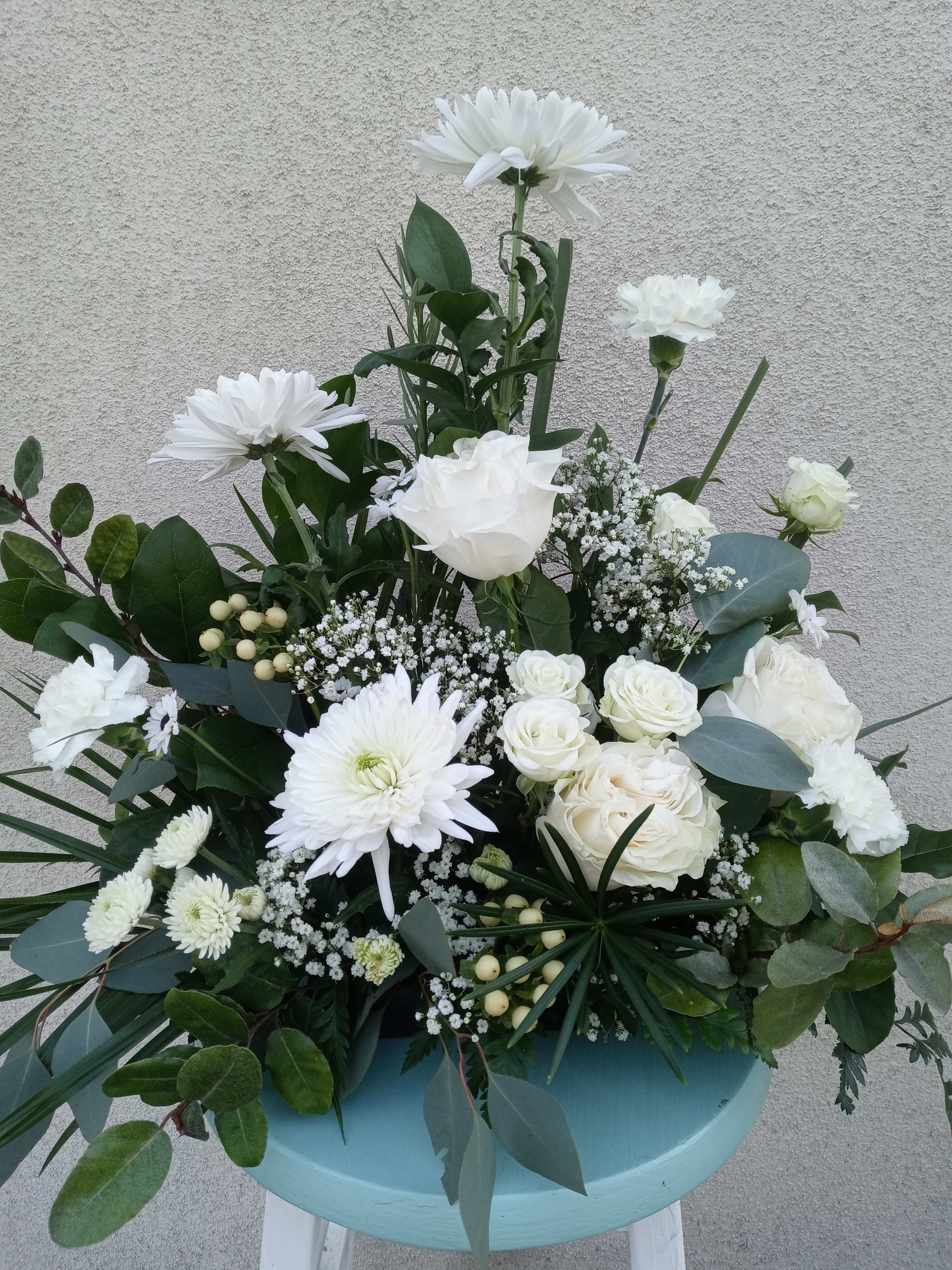 A touch of serenity - All white arrangement with assorted flowers and greens to include roses.