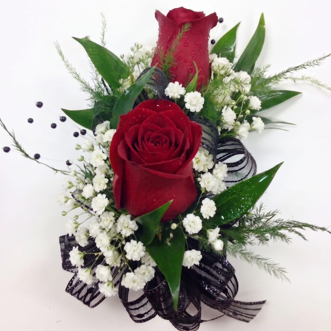 Red roses with white filler flowers and black ribbon accents