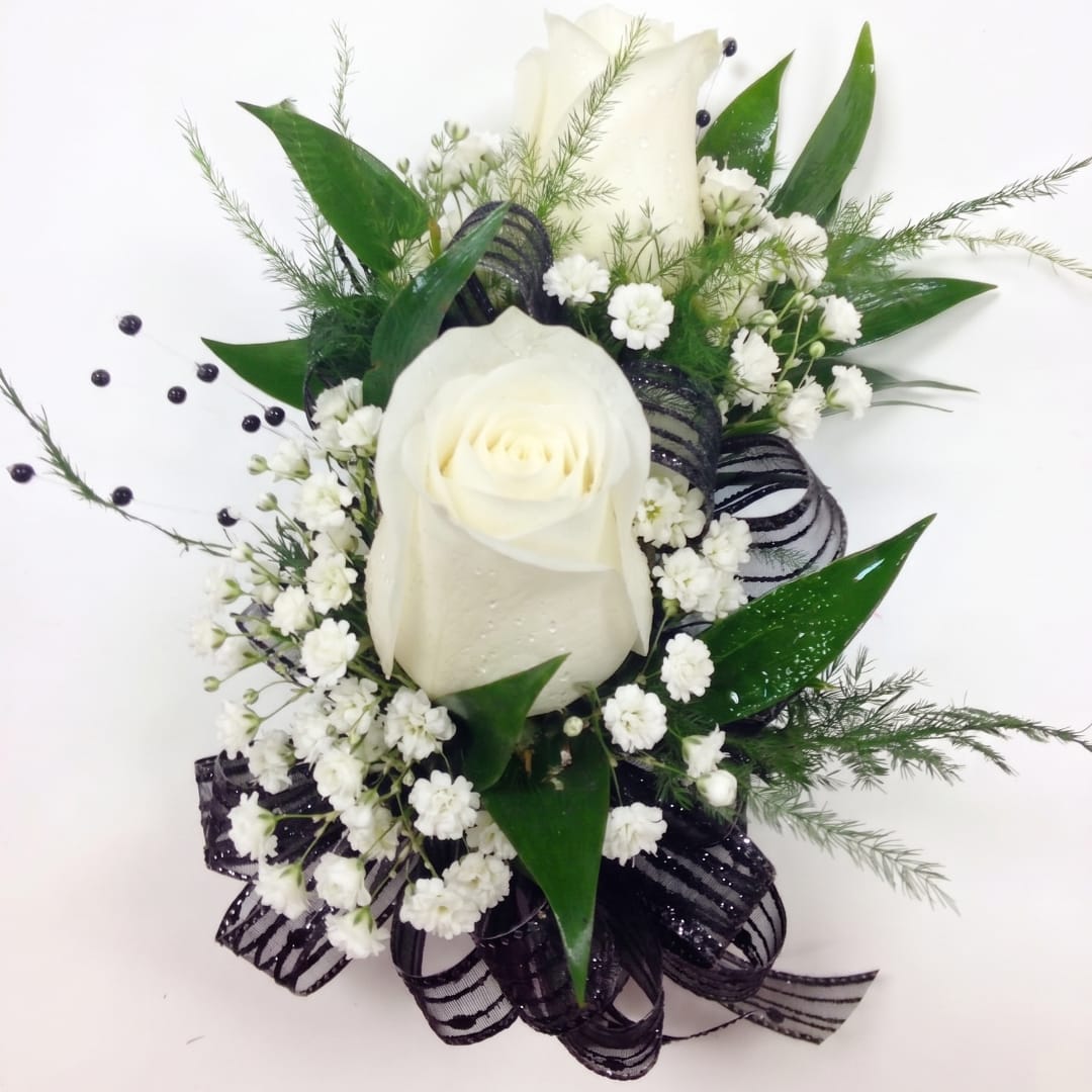 White rose arrangement with baby's breath and black ribbon on a white background