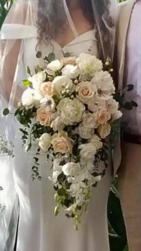 Bride holding a cascading bouquet of white and blush flowers