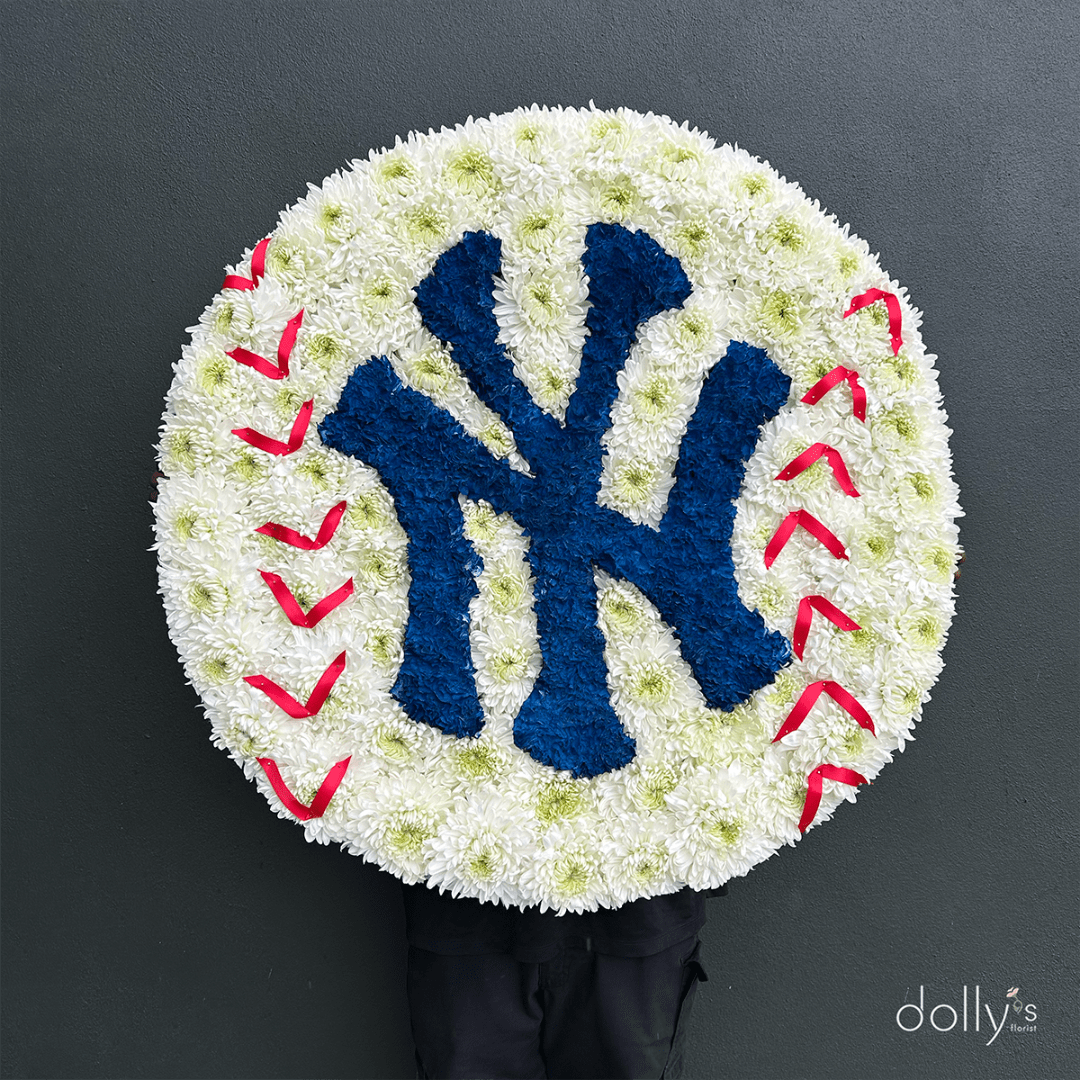 Round floral tribute with a blue Yankees logo and red stitching accents