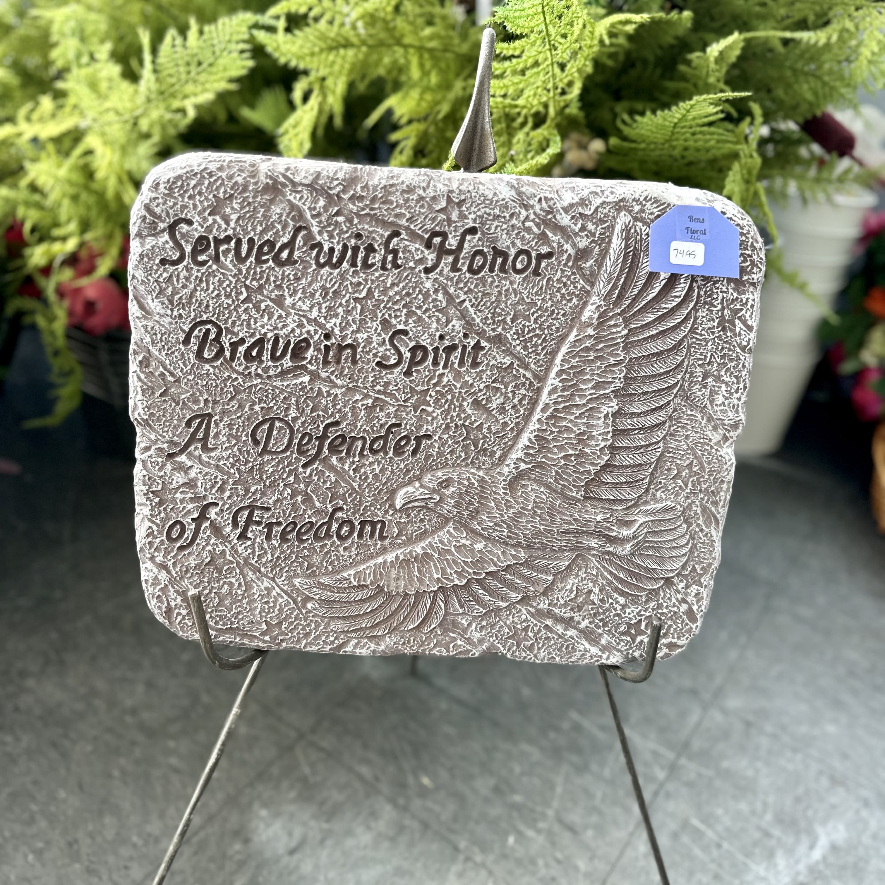 Memorial plaque with an eagle and engraved text on a stand