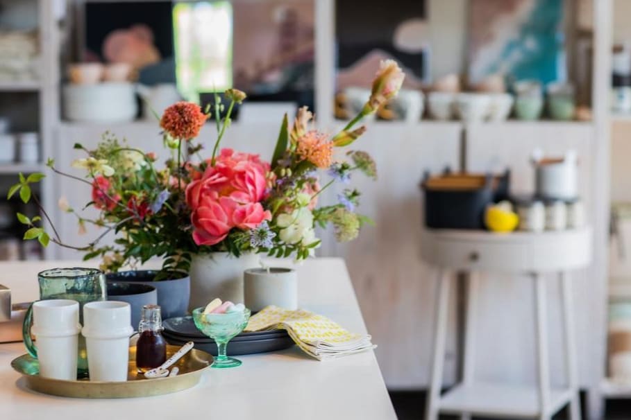 Pink Peonies arrangement on a table with glassware and candles