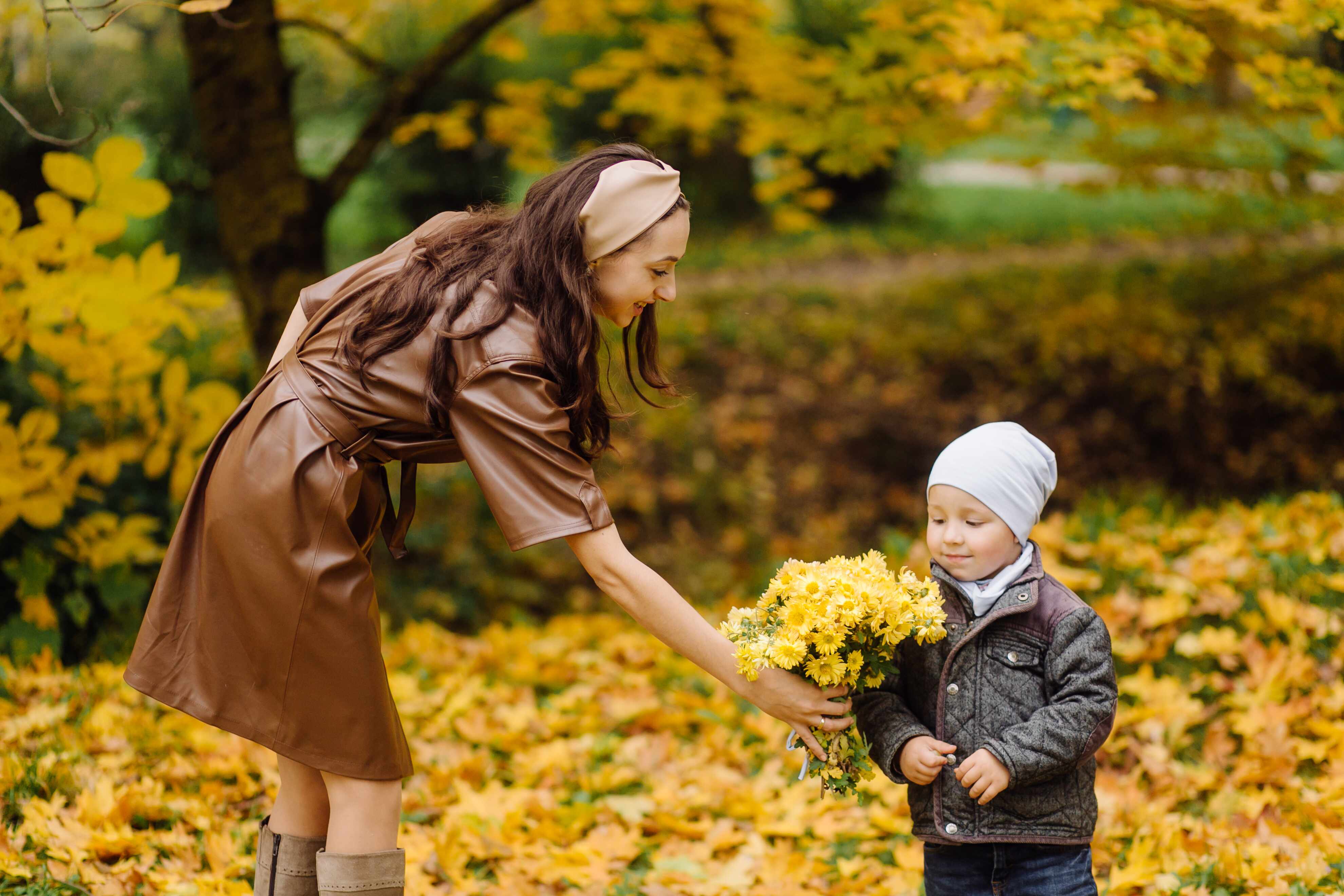 Mother and child enjoying a peaceful autumn day surrounded by colorful fall foliage in a Houston park.
