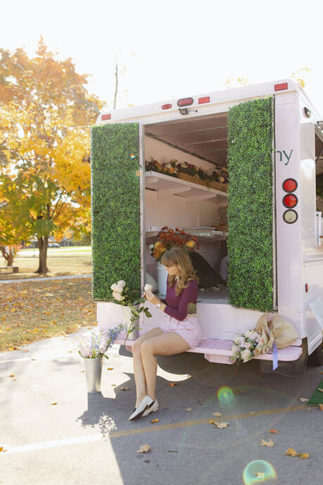 A woman sitting on the back of the truck