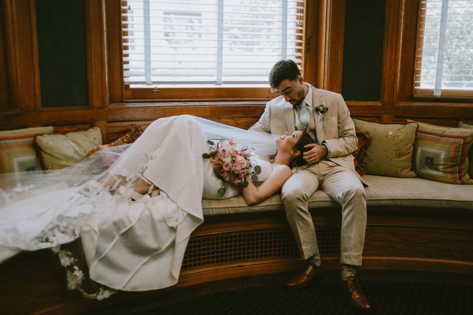 Couple posing for wedding photos holding a bouquet