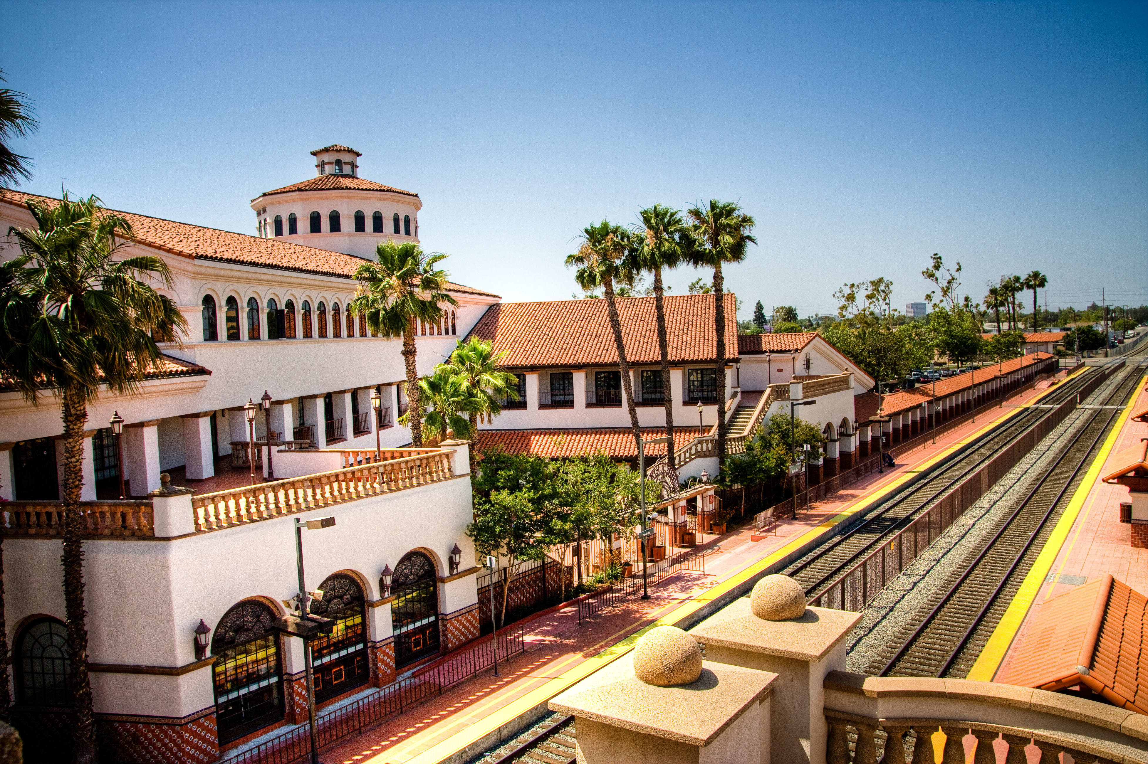 View of the train station in Santa Ana, California with train tracks running between two buildings of the station.