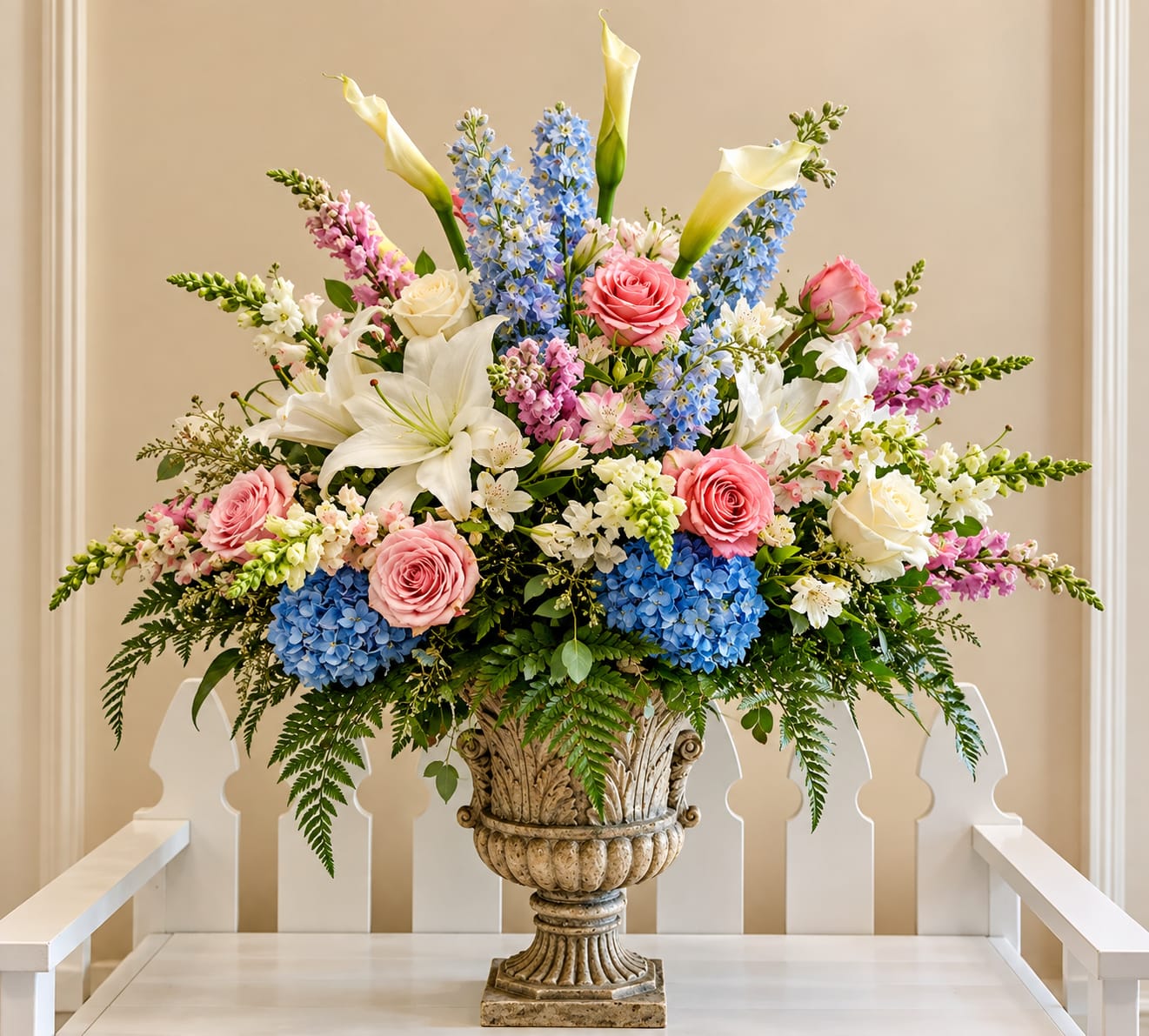 Custom floral arrangement by Legacy Florals & Gifts featuring roses, hydrangeas, lilies and seasonal flowers in an elegant urn.