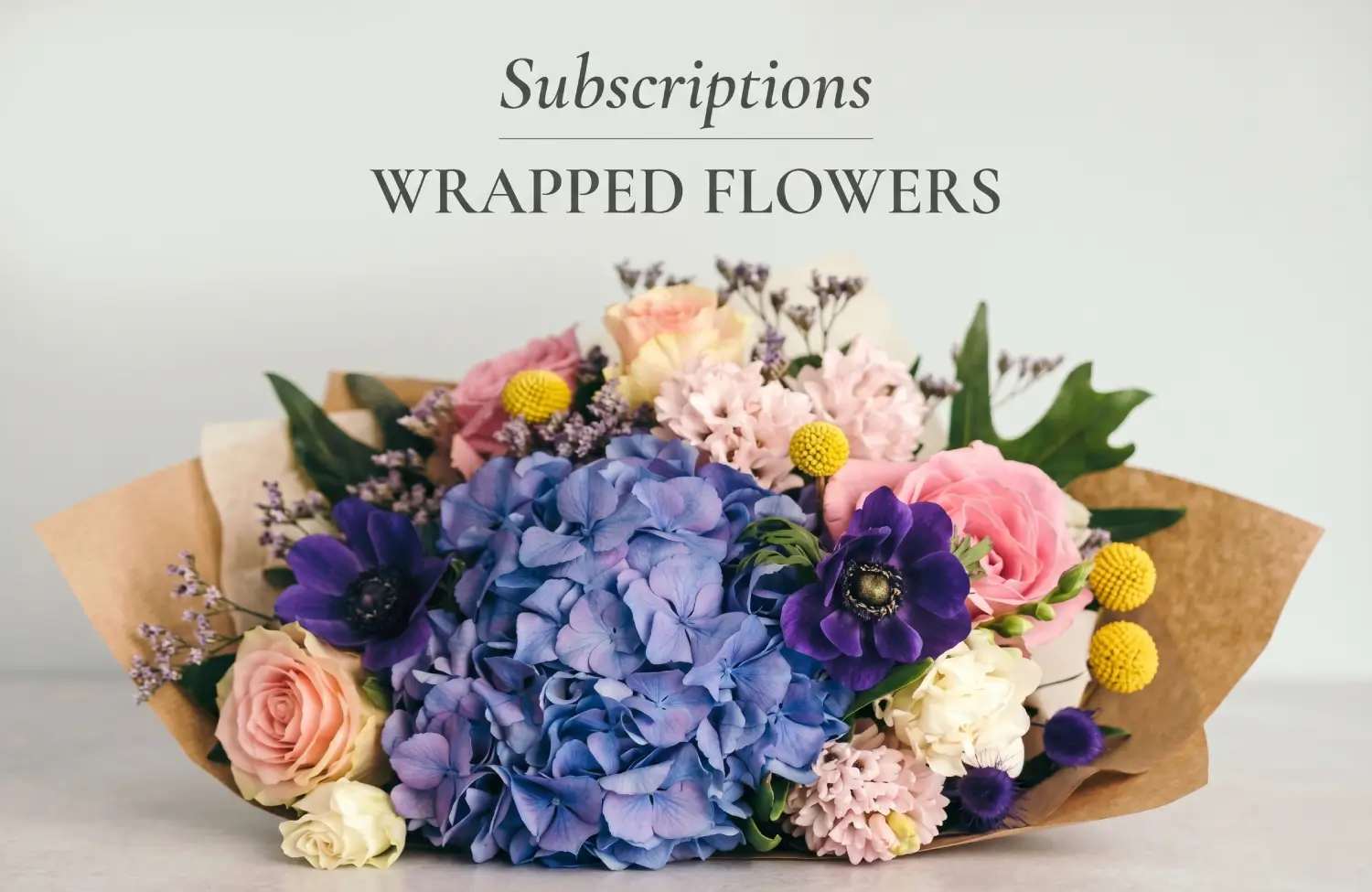 A wrapped bouquet with blue hydrangea and purple anemones, perfect for a Mother’s Day flower delivery subscription.