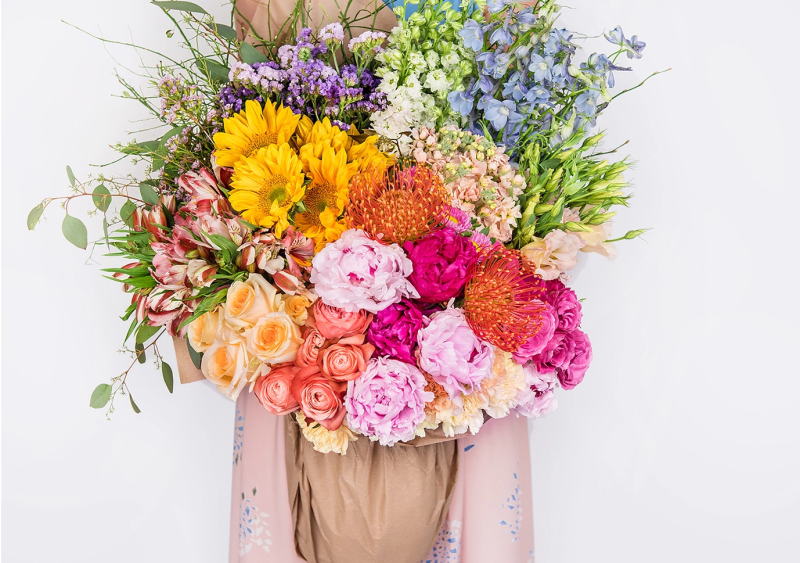 Summer floral arrangement in decorative bucket container