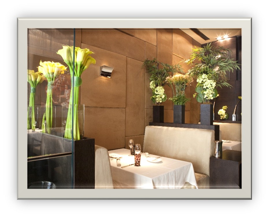 Tall vases of flowers surrounding a dining booth