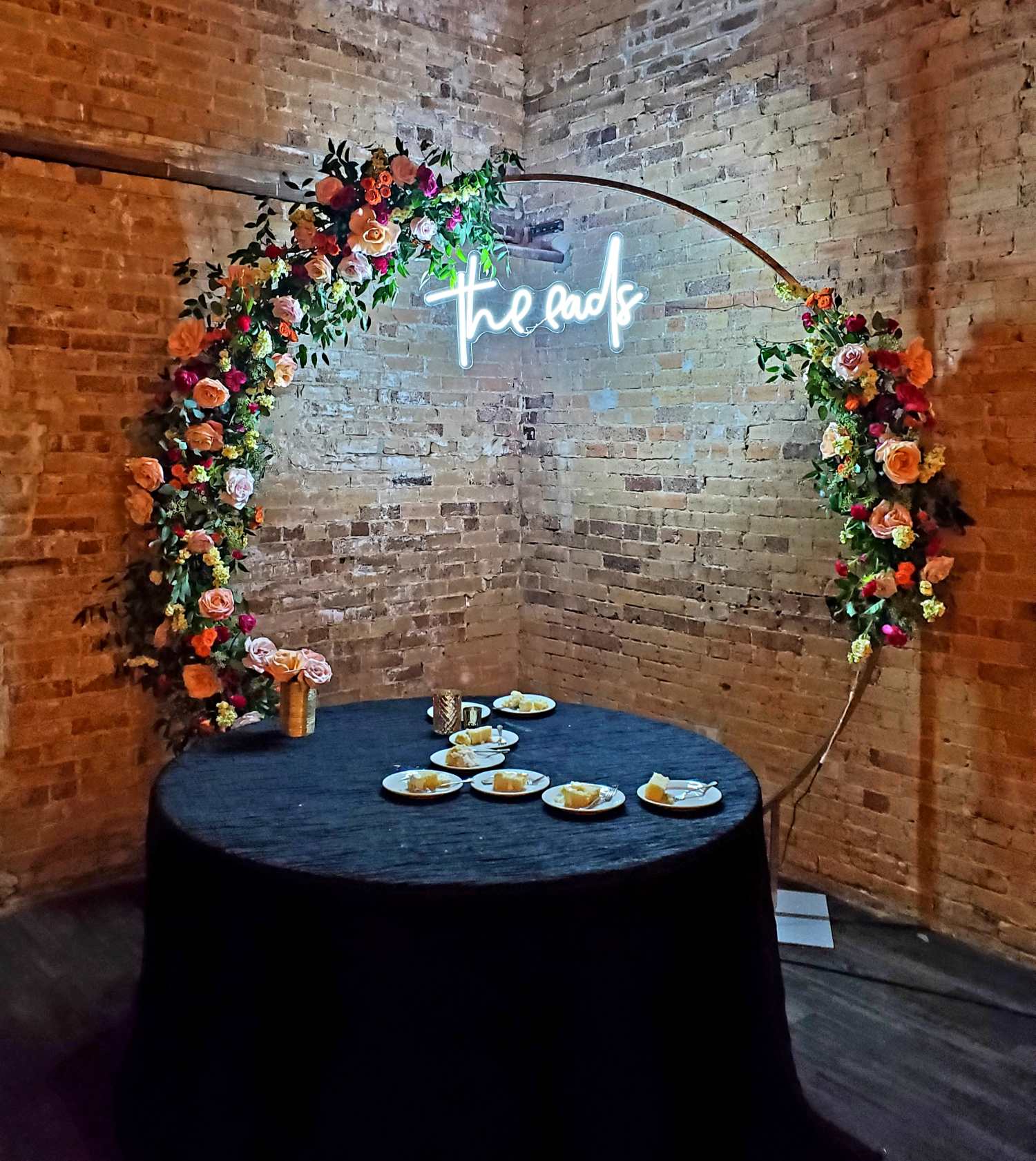 Floral backdrop on a circle with neon sign "The End"