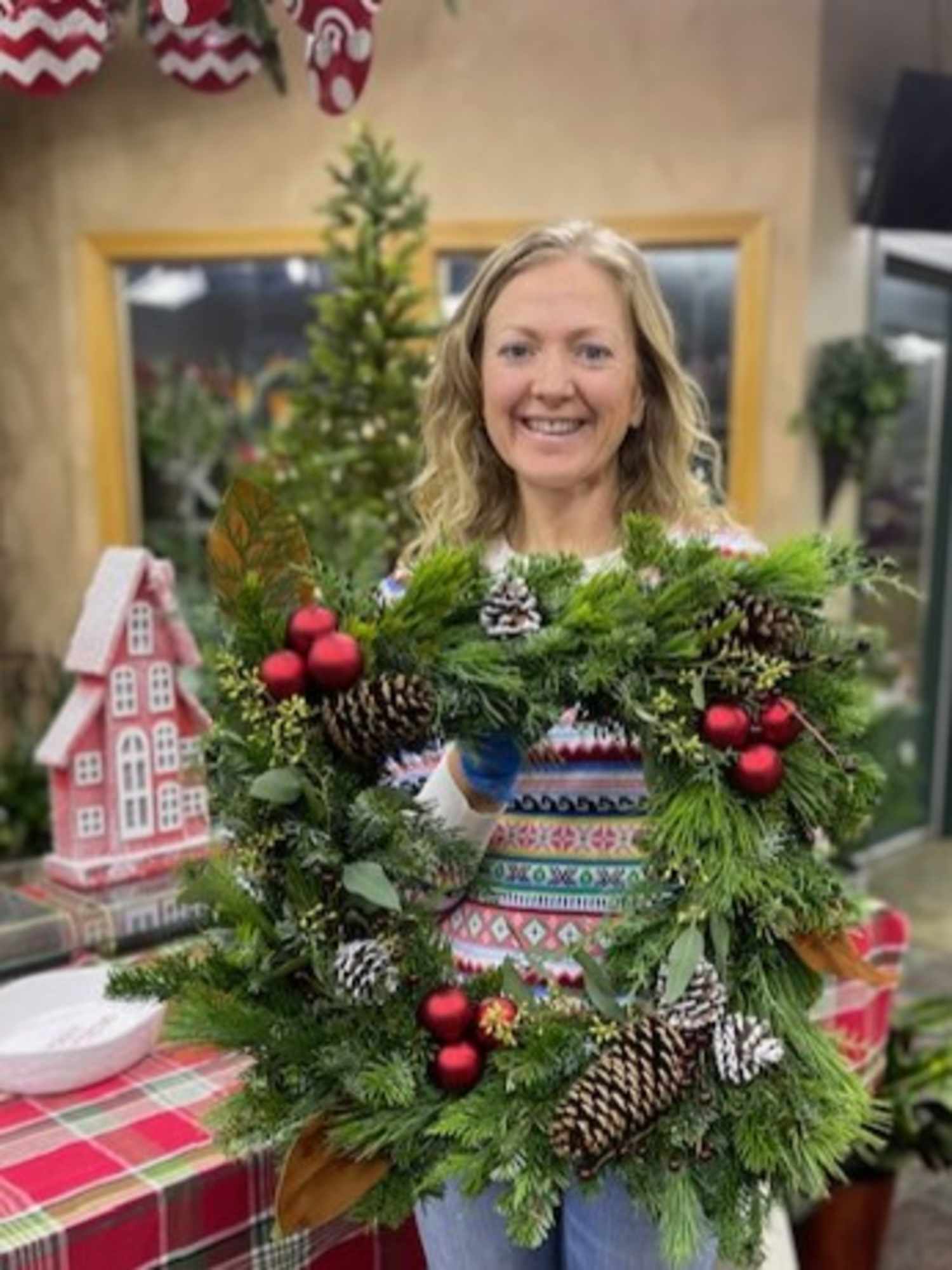 Woman holding Christmas wreath with ornaments