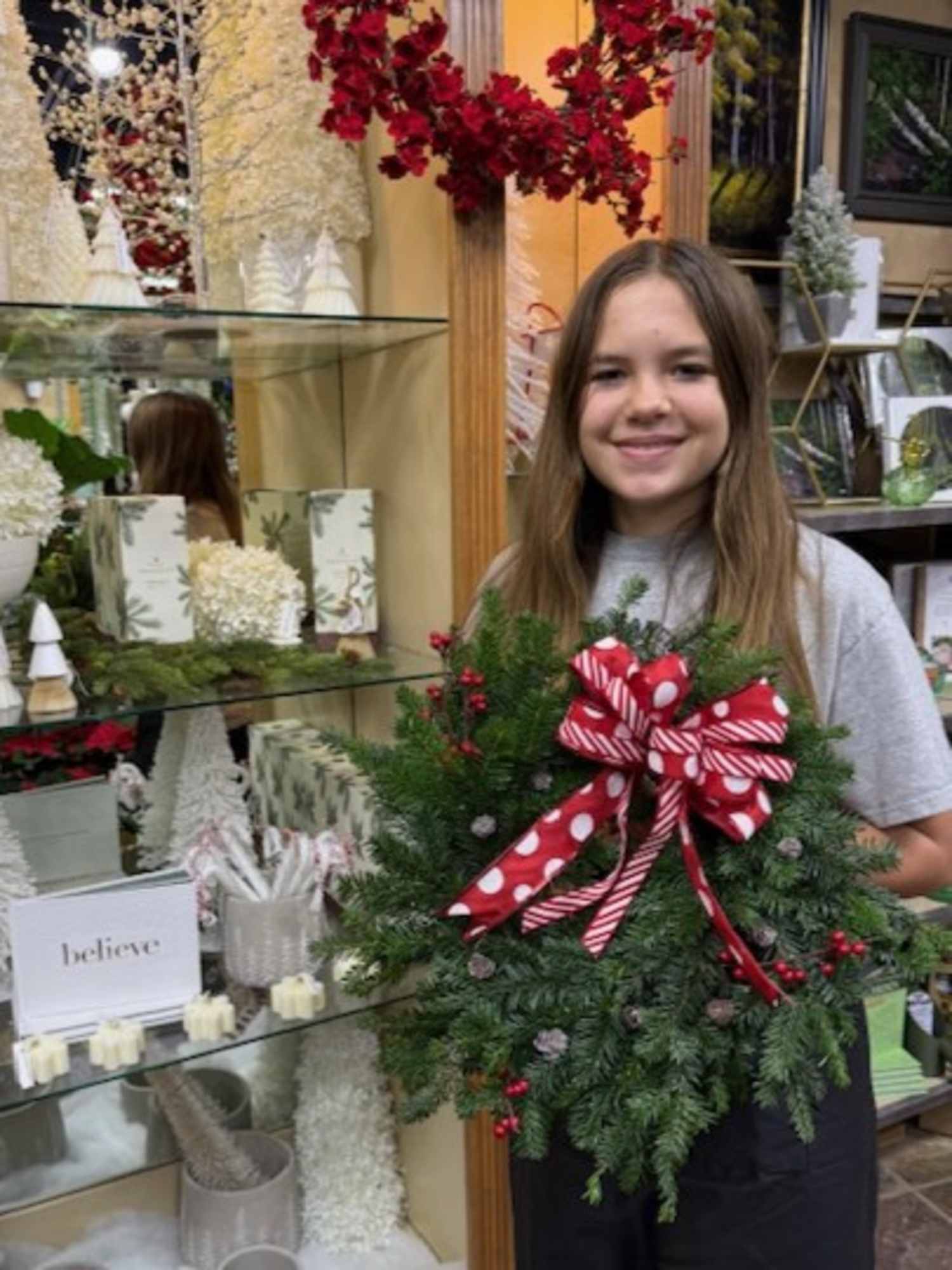 Child holding wreath with polka dot bow