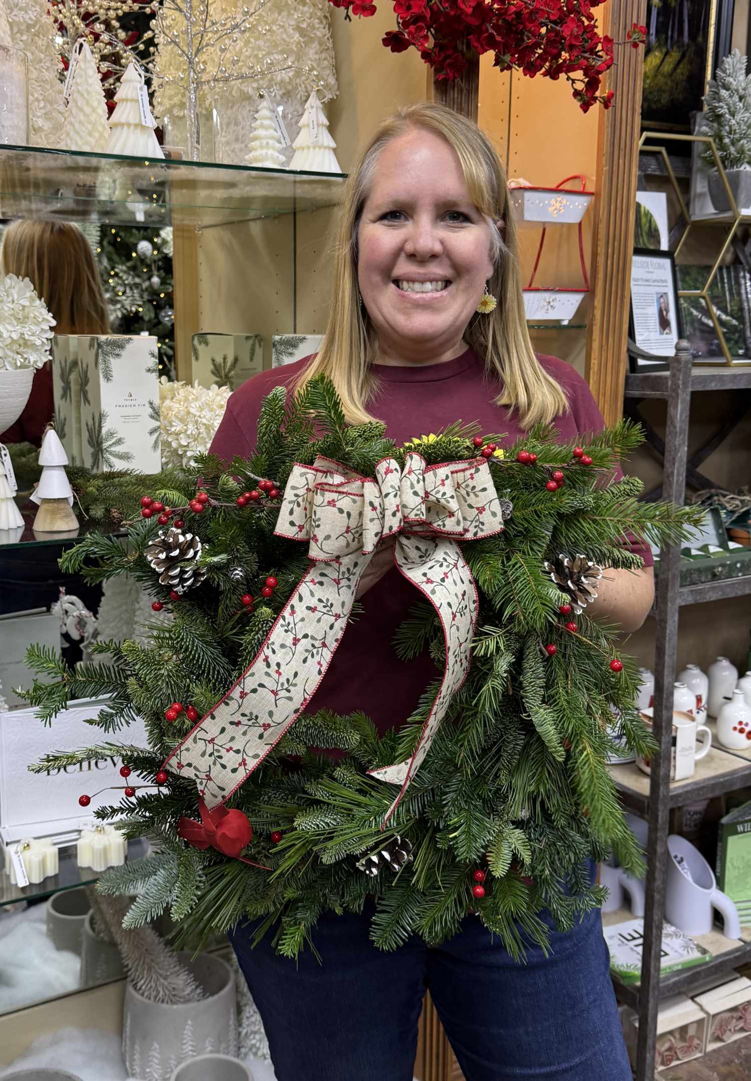 Woman holding Christmas wreath with large holiday bow