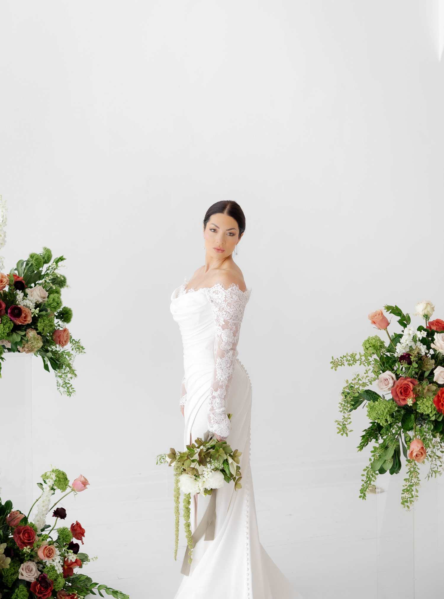 Bride surrounded by arrangments with bouquet