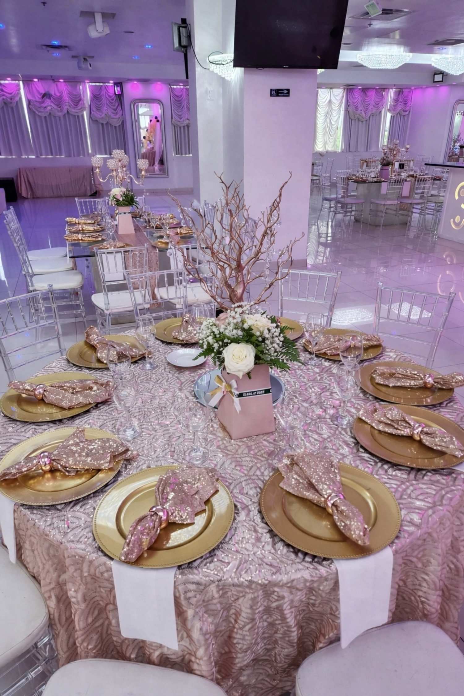 Pink and gold themed arrangements in an event hall