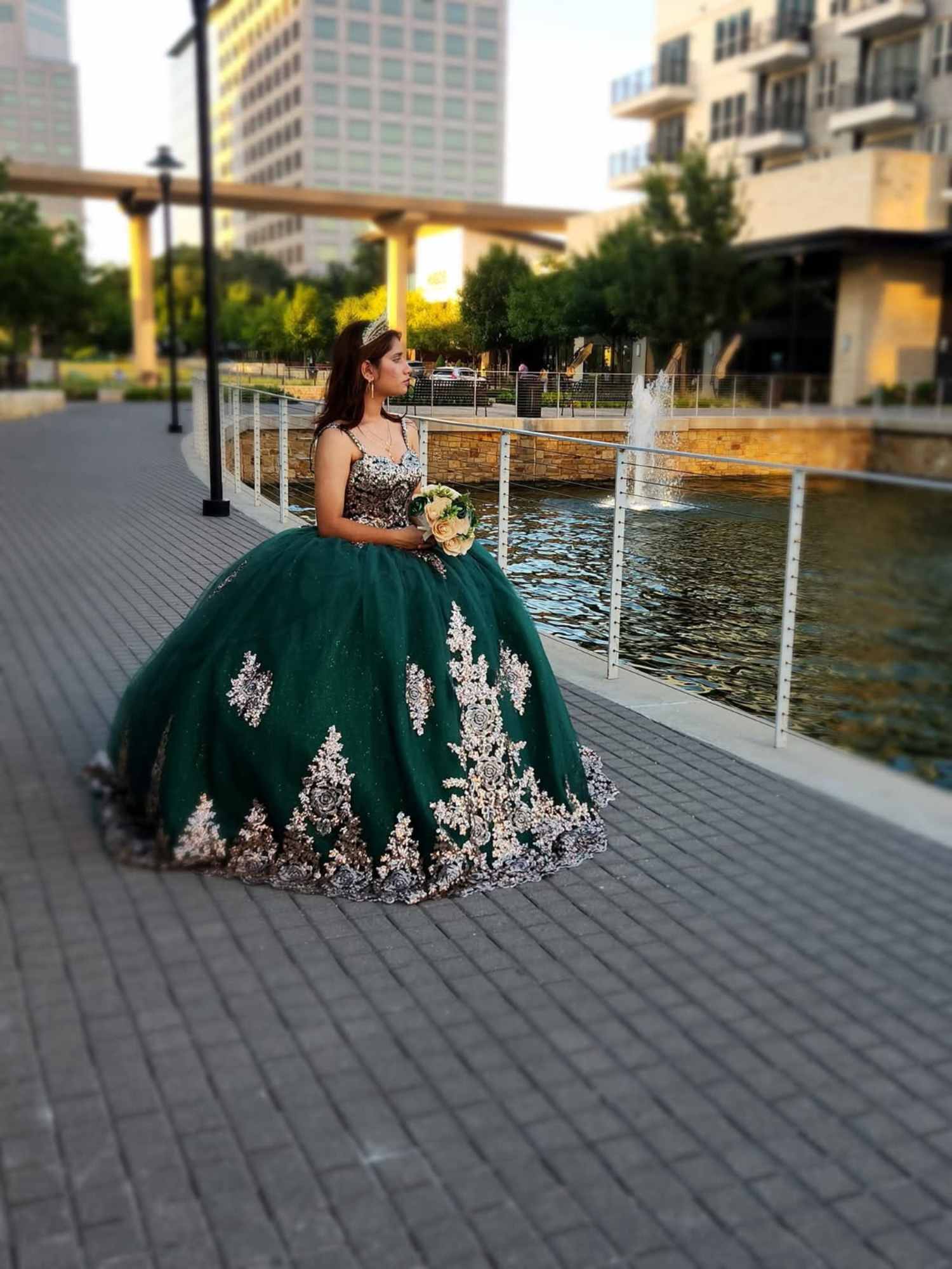 Girl in green and silver dress holding green and white rose bouquet