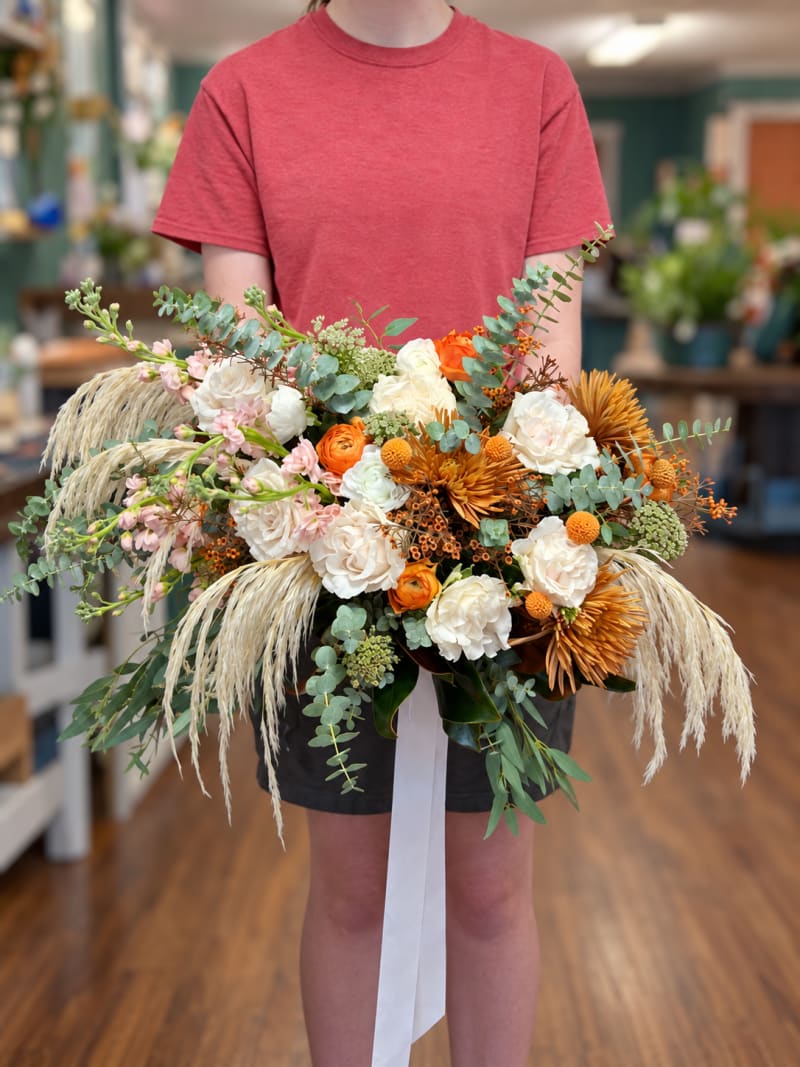 Autumn wedding bouquet in orange, ivory, and blush with pampas grass and eucalyptus.