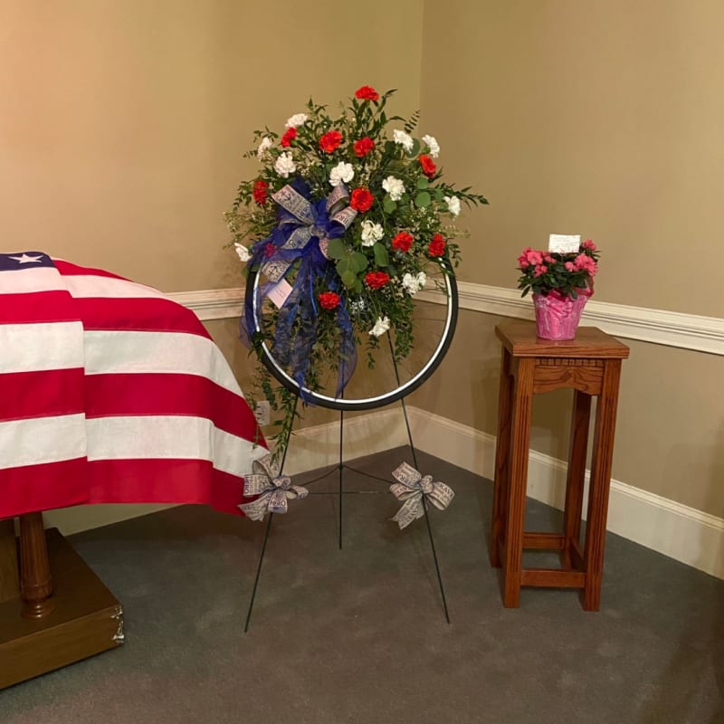 Personalized standing floral tribute with colorful flowers.