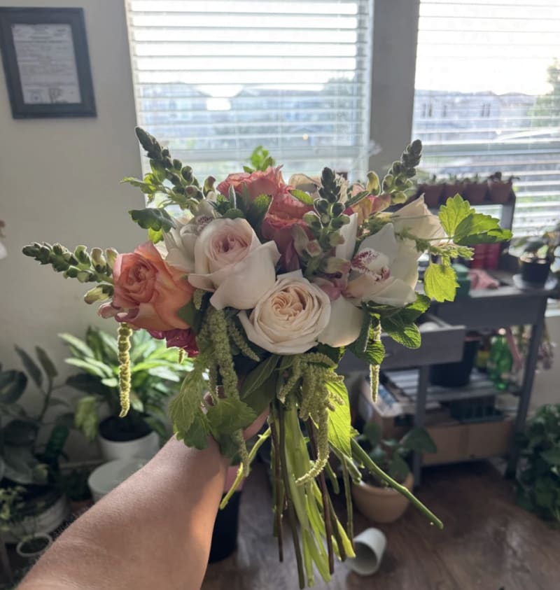 Featuring fragrant mint, soft pink snapdragons, romantic pink O'Hara roses, warm Free Spirit roses, cascading green amaranthus, and elegant white cymbidium orchids, this bouquet is filled with movement, texture, and meaningful blooms A beautiful blend of 