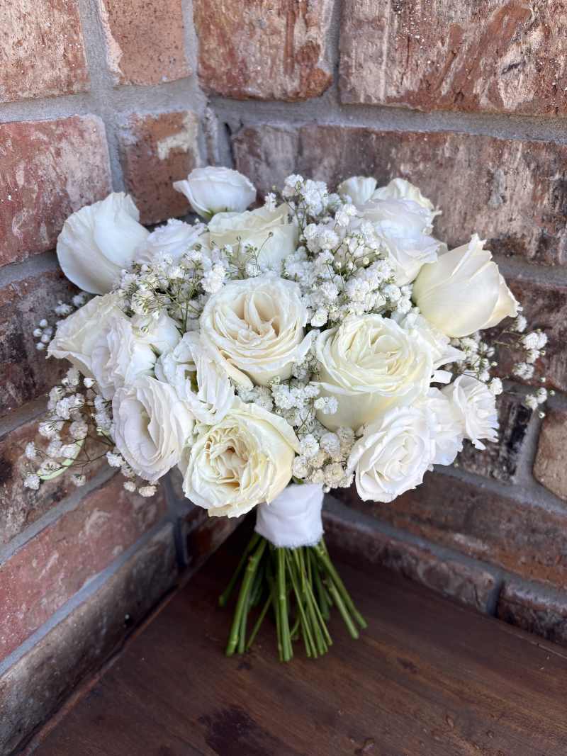 classic white roses, delicate white lisianthus, and airy clouds of baby's breath.