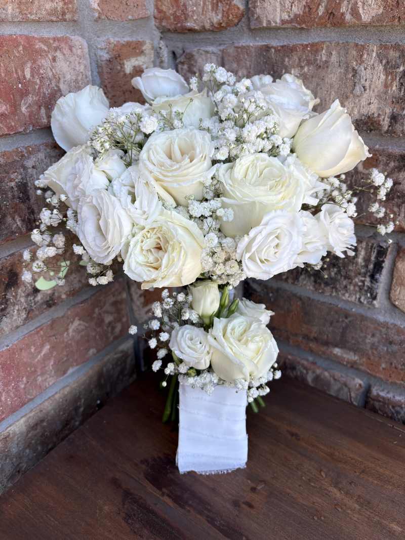 features classic white roses, delicate white lisianthus, and clouds of baby's breath for a soft, romantic look. Full of texture and elegance.