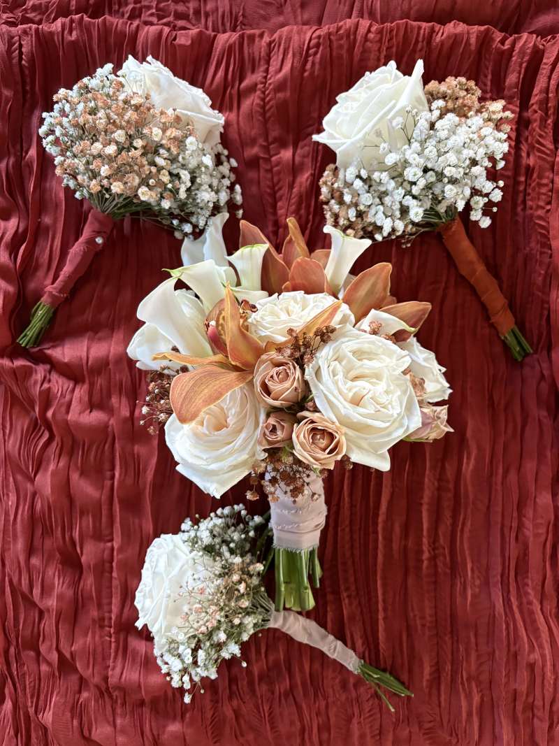 he bridal bouquet featured elegant white calla lilies, white and coffee-colored spray roses, brown cymbidium orchid and subtle touches of terracotta-tinted baby's breath for warmth and texture.