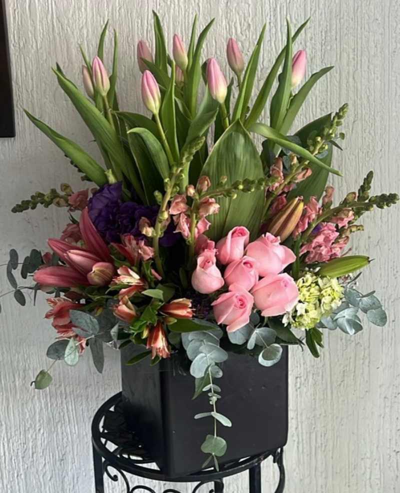 Pink tulips (tulipanes rosas) Pink roses (rosas rosas) Lilies (lirios) Snapdragons (boca de dragón) Hydrangeas (hortensias) Eucalyptus (eucalipto)