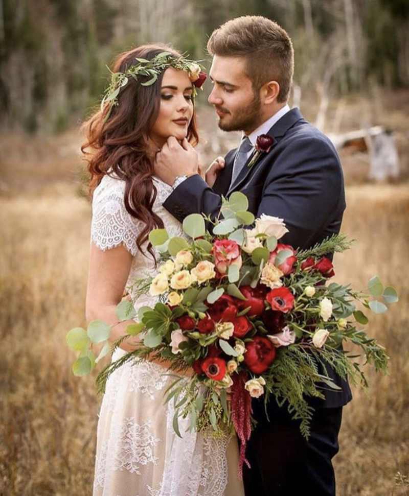 Bride holding a colorful bridal bouquet with the groom.