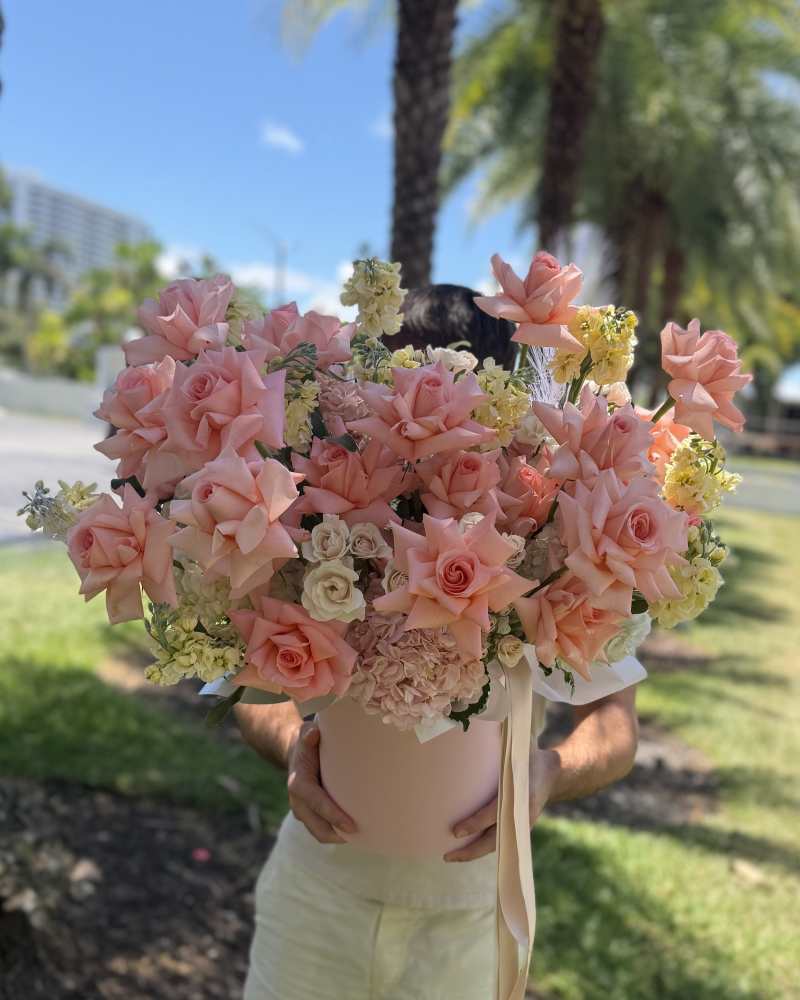Blush pink rose flower box with hydrangeas and delicate seasonal flowers held outdoors in Miami.