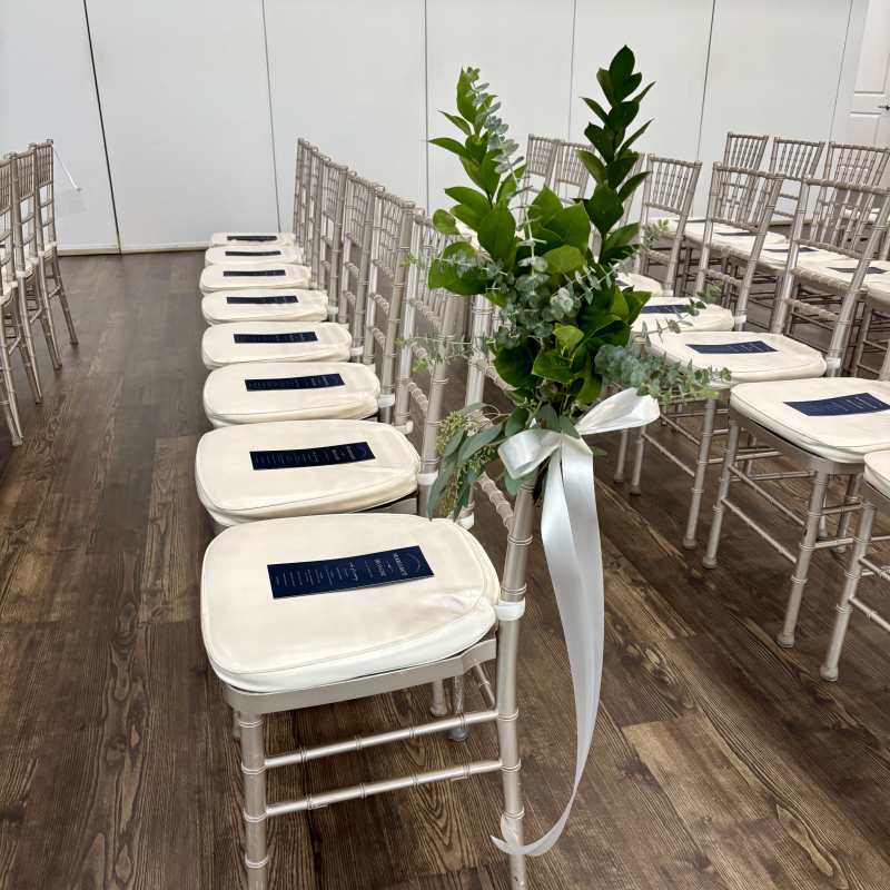 Greenery for the bridal ceremony on the chairs down the aisle