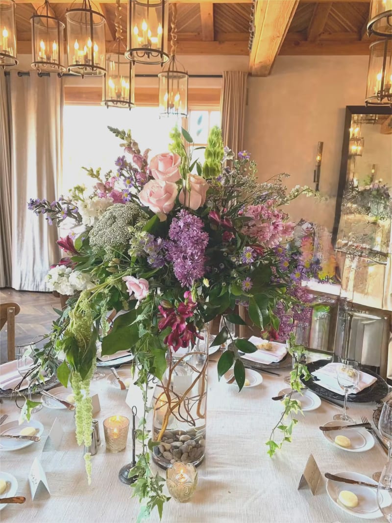 Tall floral centerpiece with pink, purple, and green blooms on a reception table at Rancho Valencia Resort & Spa in San Diego.