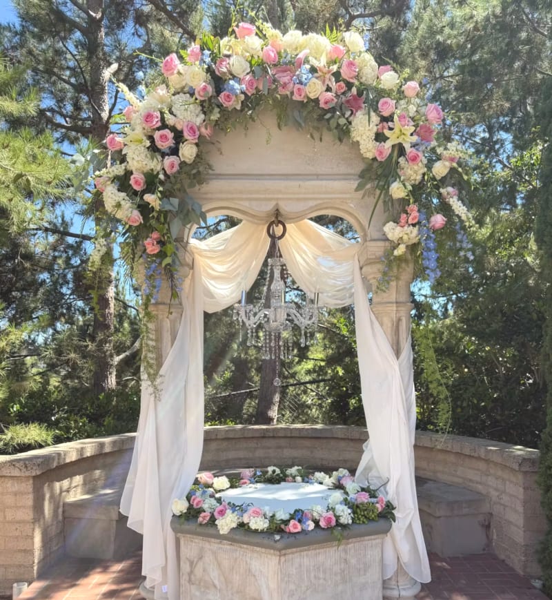 Pastel colored blooms at The Prado's wishing well