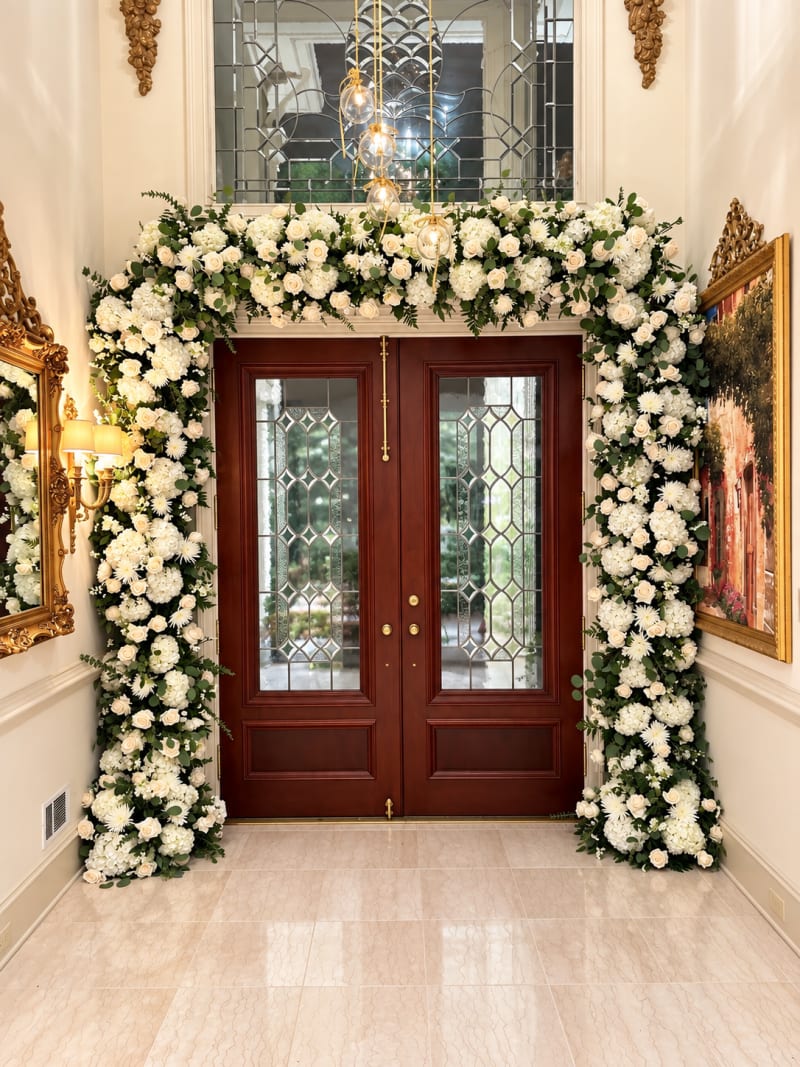 White rose and hydrangea floral installation surrounding double doors by Legacy Florals & Gifts