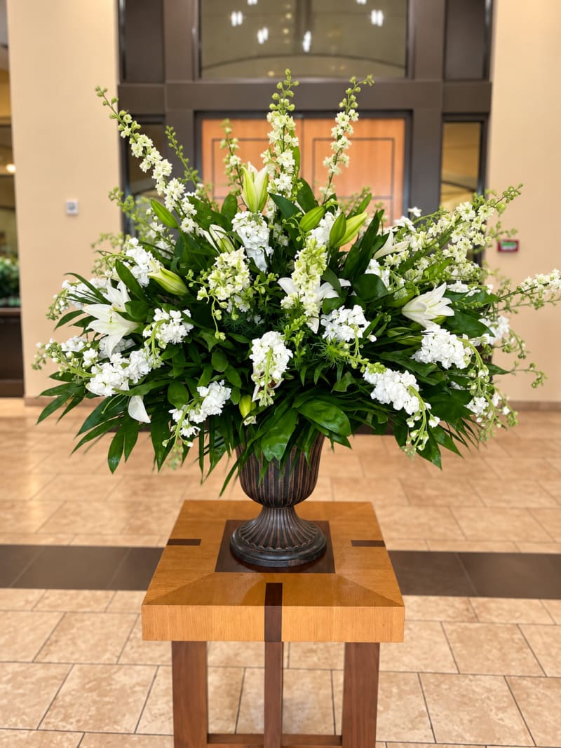 Large white floral arrangement in urn by Legacy Florals & Gifts
